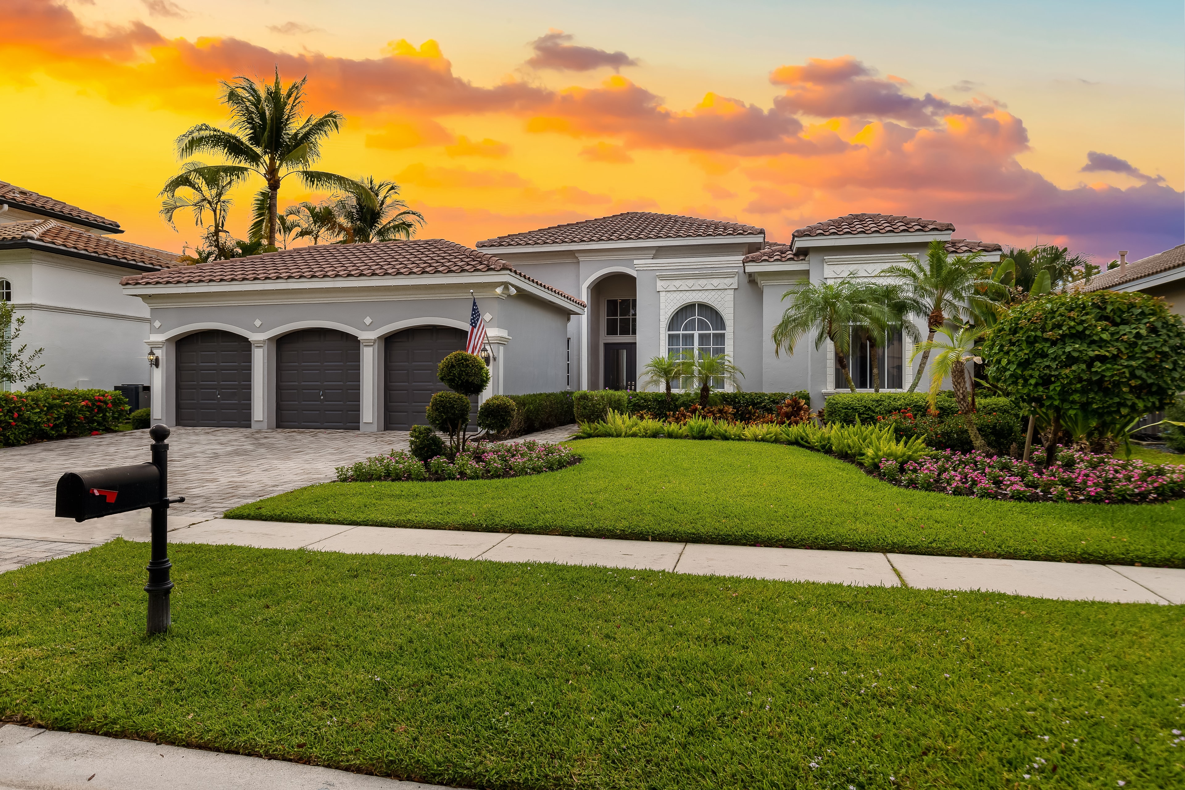 Luxury South Florida home with manicured lawn at sunset